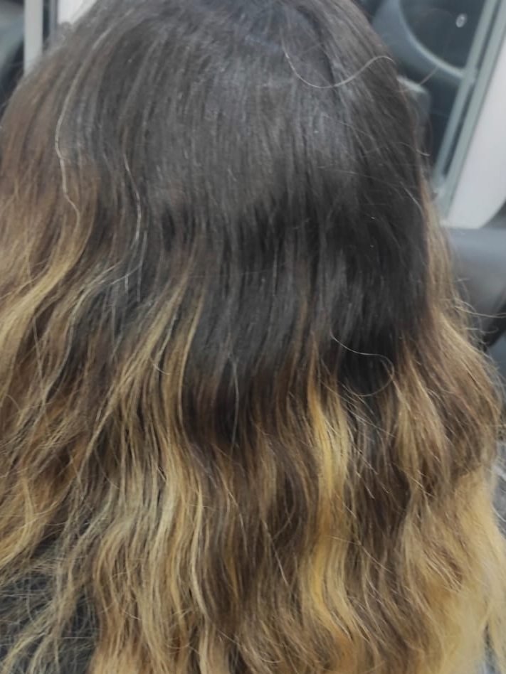 Antes del balayage: raíz oscura crecida y puntas amarillas con una línea marcada donde acababa el color, vista de espaldas