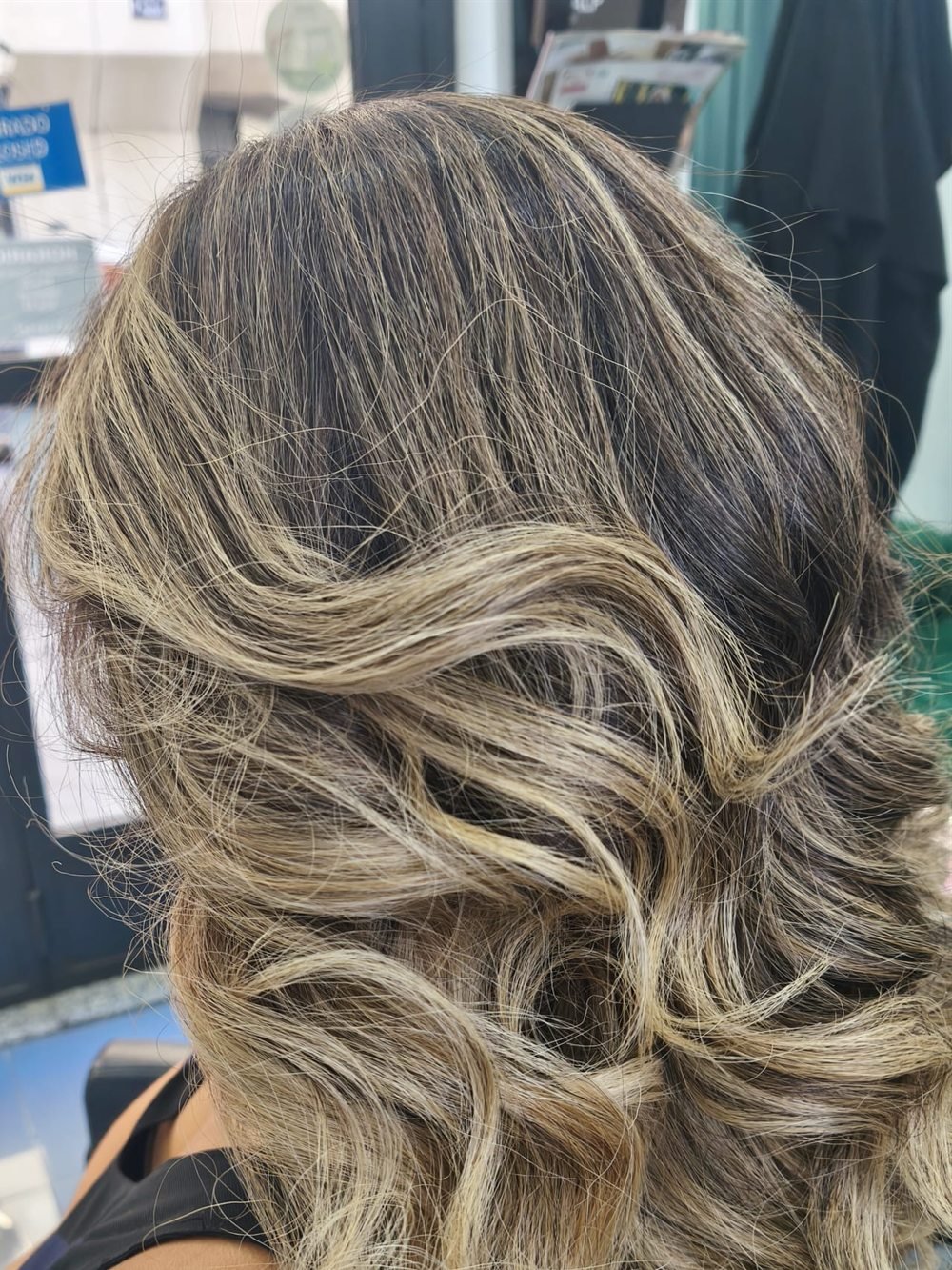 Balayage rubio beige con ondas marcadas, visto de lado en el salón