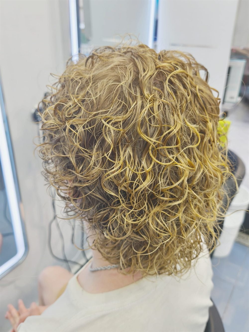 Permanente sobre cabello rubio: rizo pequeño y definido en media melena